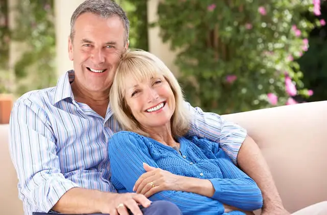 Relationship Compatibility - Happy older couple relaxing on sofa