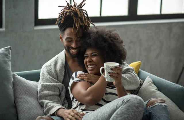 Happy young African-American laughing on couch