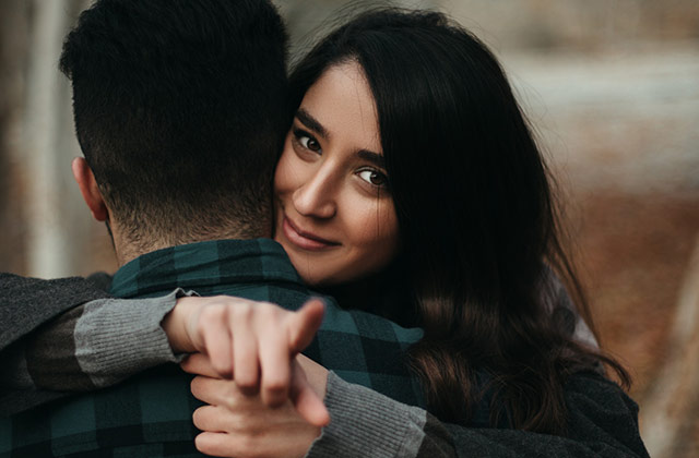 How to Make Him Commit to You- Lady hugging her man and pointing her finger How to Make Him Commit to You- Lady hugging her man and pointing her finger