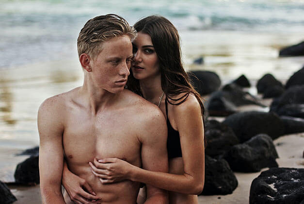 How to Compliment a Guy-Young couple at seaside with lady holding guy's abs from behind How to Compliment a Guy-Young couple at seaside with lady holding guy's abs from behind