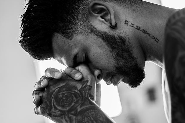 Questions to Ask Yourself Before Getting Ex Back-Black and white photo of tattooed man lost in thought with head on clasped hands Questions to Ask Yourself Before Getting Ex Back-Black and white photo of tattooed man lost in thought with head on clasped hands