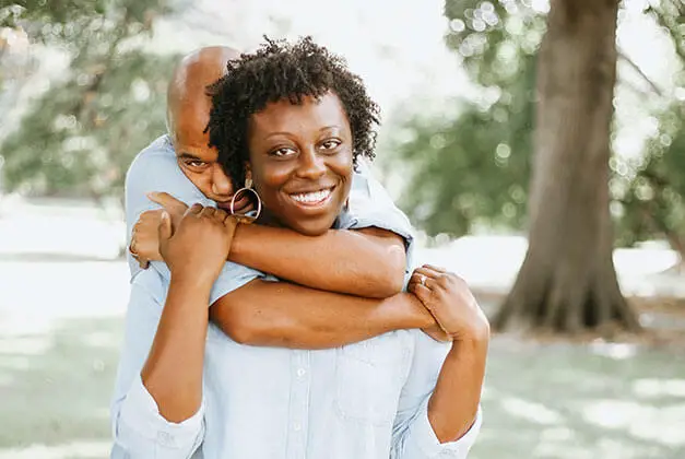 True Differences Between Being In Love And Loving Someone - Smiling lady with her guy embracing her from the back True Differences Between Being In Love And Loving Someone - Smiling lady with her guy embracing her from the back