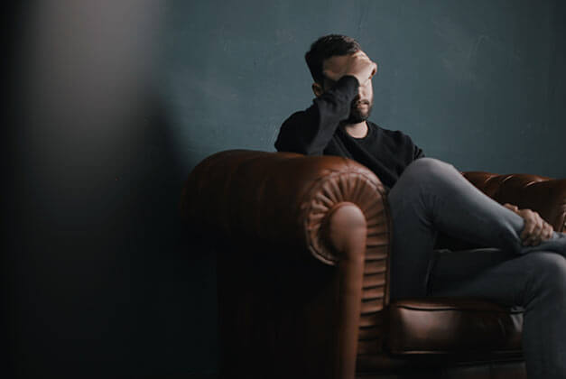 Why Do Men Pull Away - Heartbroken man sitting alone with hand on his head Why Do Men Pull Away - Heartbroken man sitting alone with hand on his head