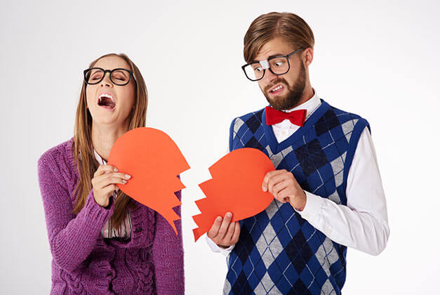 Why Guys Pull Away - Breaking up couple holding split parts of heart symbol Why Guys Pull Away - Breaking up couple holding split parts of heart symbol