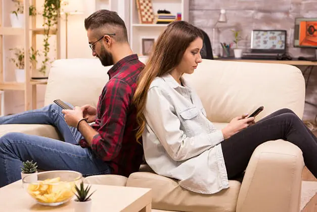 How to Save Your Relationship - Young couple sitting back-to-back on sofa after disagreement