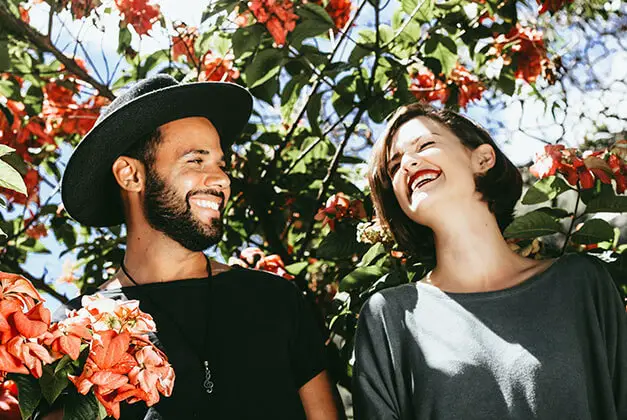 Personal Happiness Opens Your Heart - Happy Couple smiling at each other in colorful garden Personal Happiness Opens Your Heart - Happy Couple smiling at each other in colorful garden
