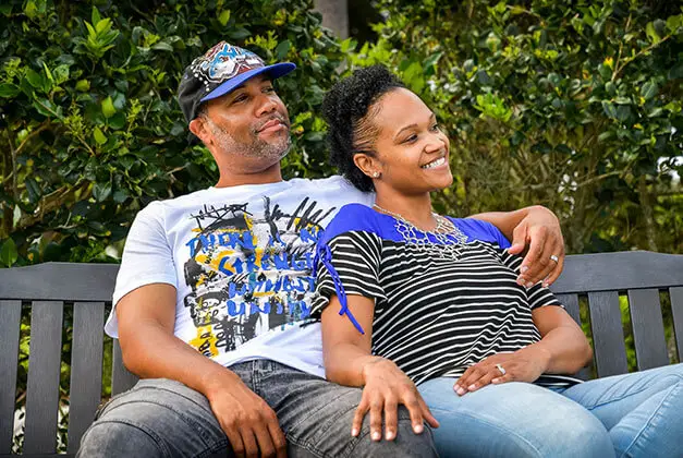 Personal happiness and finding true love - Happy African-American couple sitting on a park bench Personal happiness and finding true love - Happy African-American couple sitting on a park bench