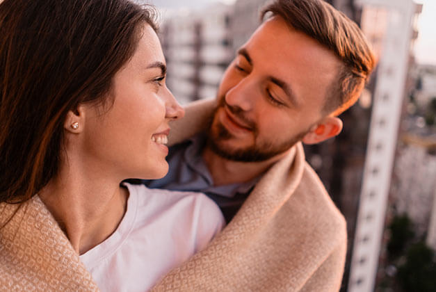 How to Communicate Effectively With a Man - Happy couple smiling at each on their balcony during sunset How to Communicate Effectively With a Man - Happy couple smiling at each on their balcony during sunset