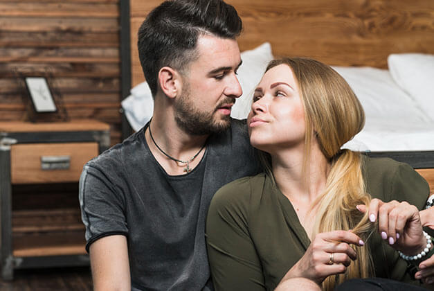 How to Communicate in a Relationship with a Man - Romantic young couple sitting in bedroom and looking at each other How to Communicate in a Relationship with a Man - Romantic young couple sitting in bedroom and looking at each other